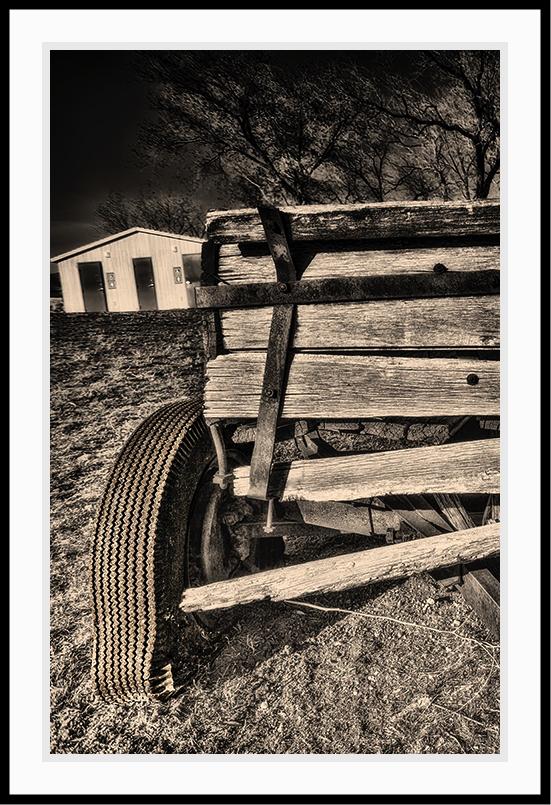 Sepia toned print of an old wagon with a broken wheel.